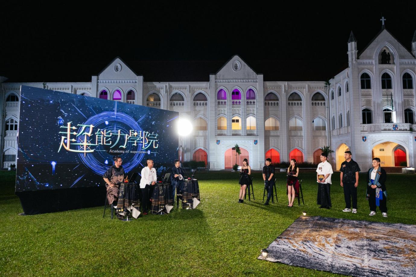 A group of people performing in front of a large screen
AI-generated content may be incorrect.